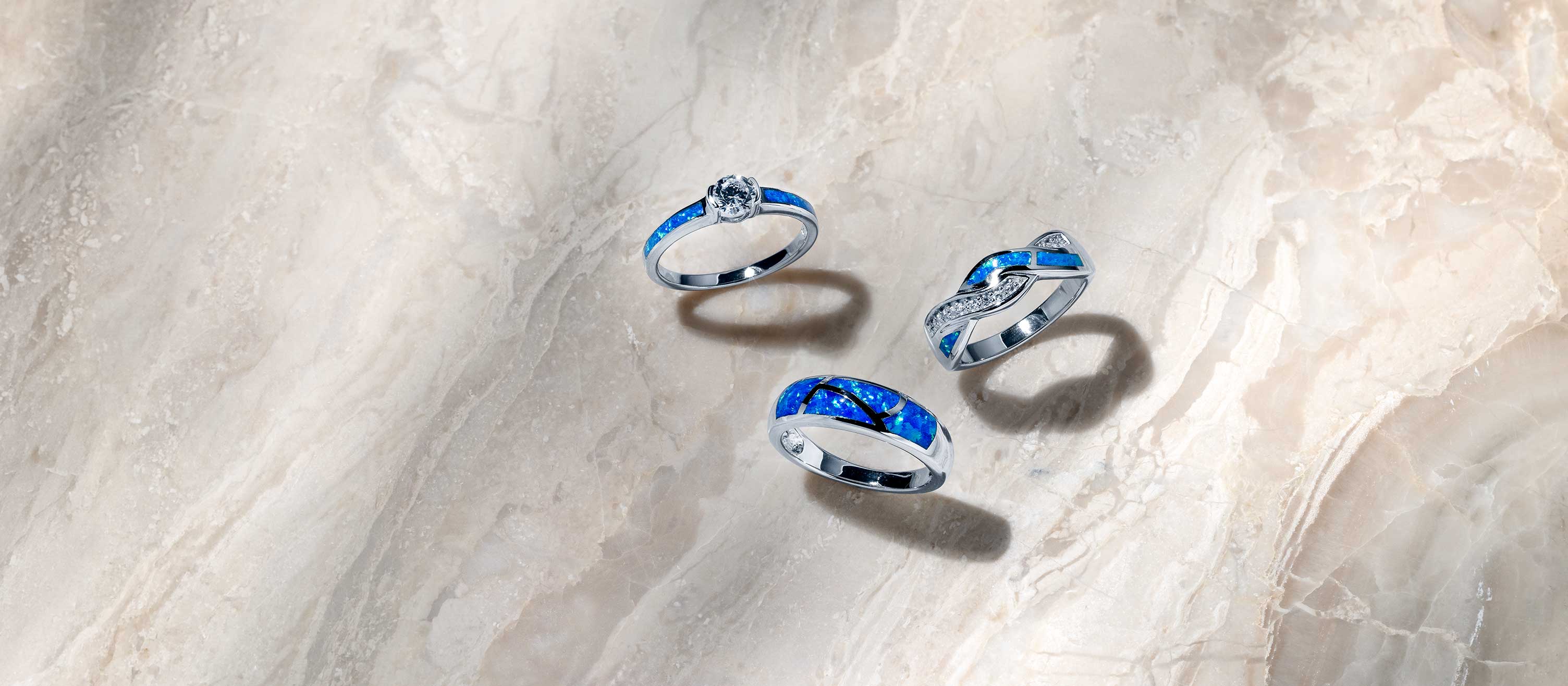 A Blue Opal collection styled together — iridescent inlay necklaces, rings, and earrings