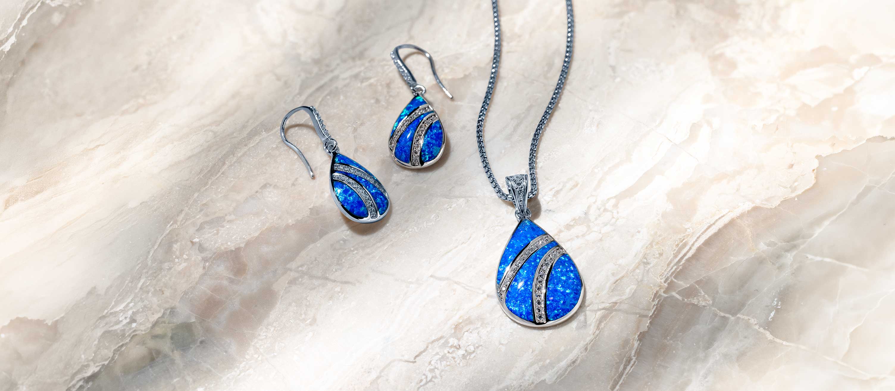 Blue Opal pieces styled together — layered necklaces, stacked rings, ocean drop earrings