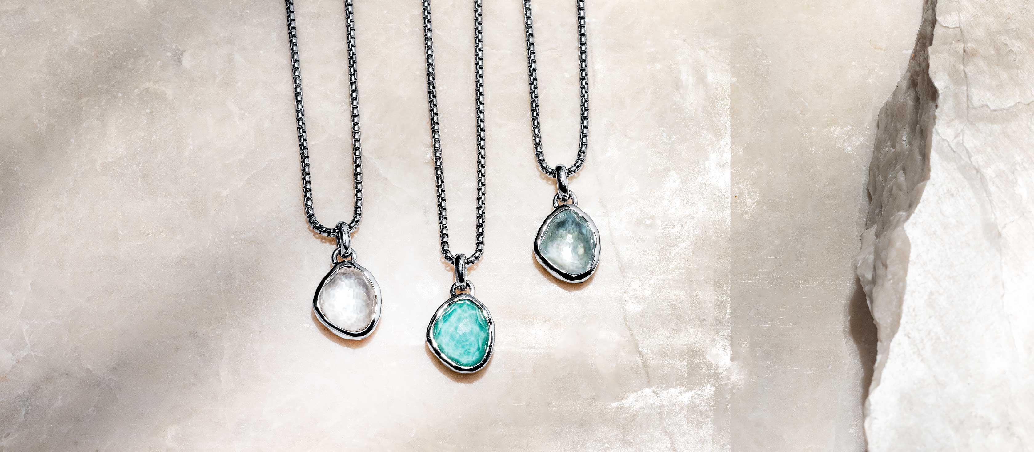 Laguna Key pieces styled together — layered necklaces, stacked rings, sea pebble drops